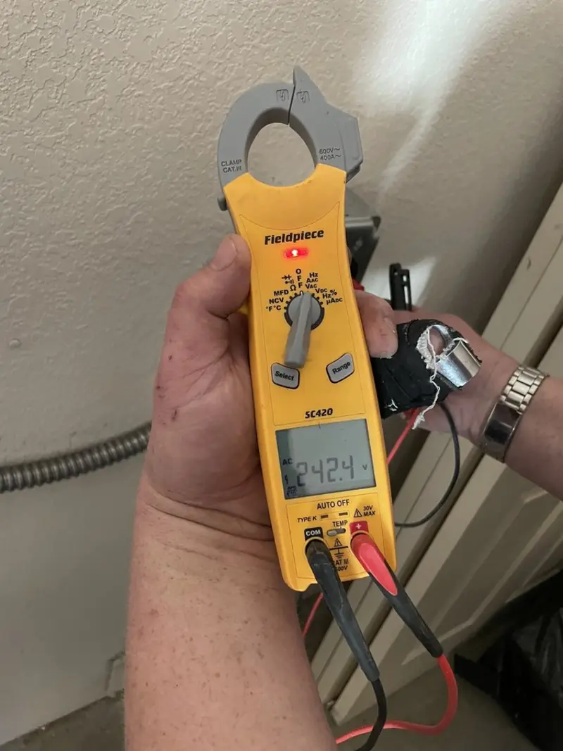 Voltage testing with clamp meter during Outlet Installation in Rio Bravo